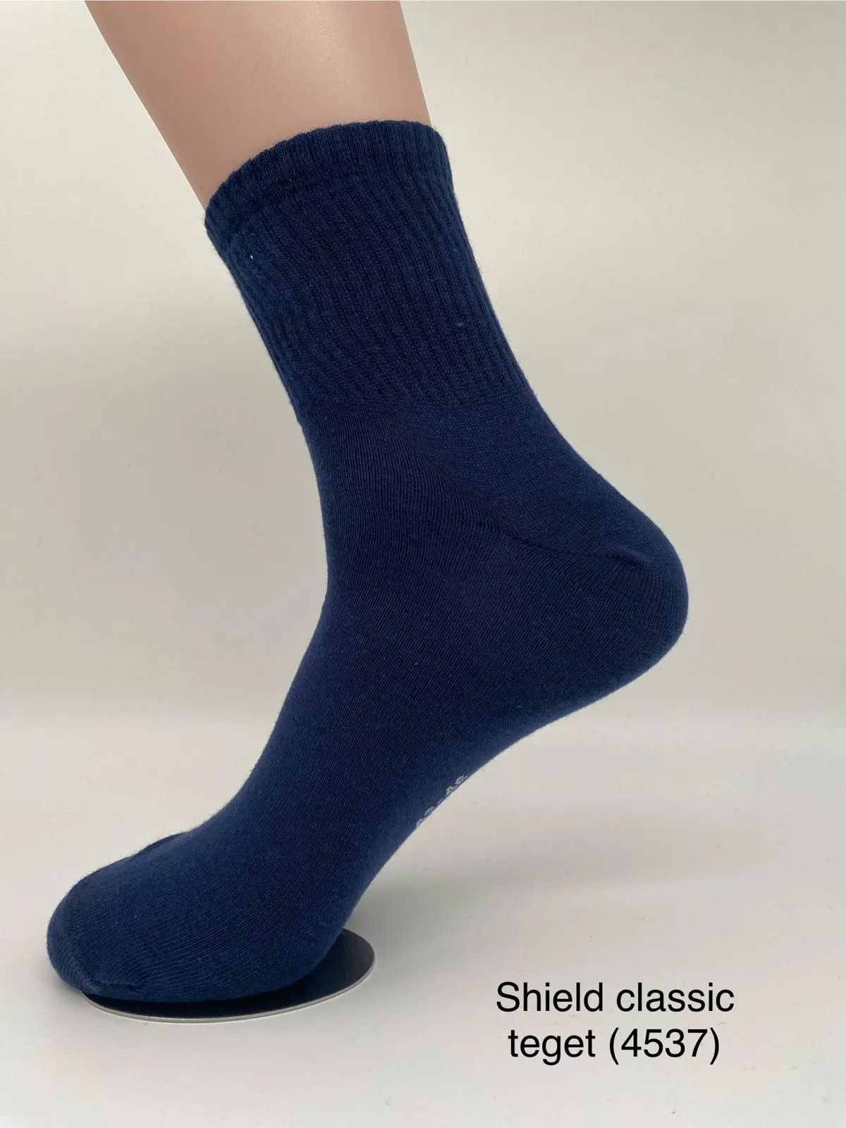 Navy crew-length sock on a foot form.